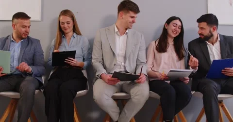 Group of young professionals sitting on chairs, preparing for job interview or Stock Footage 321632330