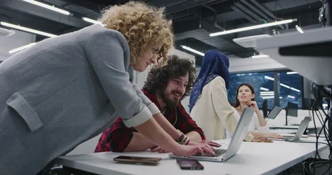 Group Of Young Programmers Sitting At Desks Working On Computers In It Office Stock Footage
