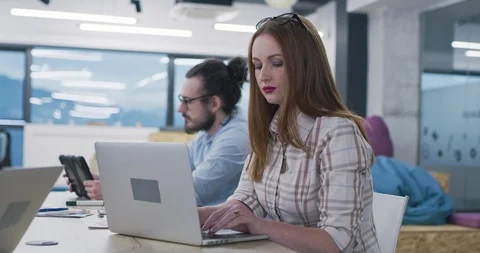 Group Of Young Programmers Sitting At Desks Working On Computers In It Office Stock Footage 113974004