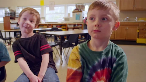 A group of young school kids sit in chairs and have fun with the camera Stock Footage 34004889