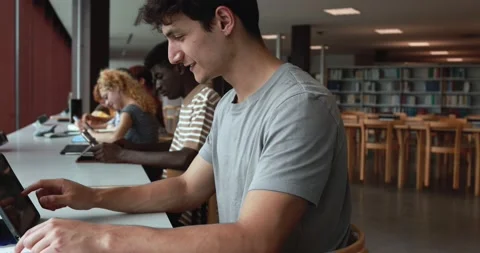 Group of young students learing together inside school library Stock Footage 203721195