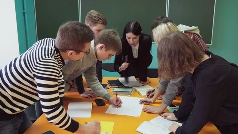 Group of young students making task under teacher's supervision Stock Footage 86326582
