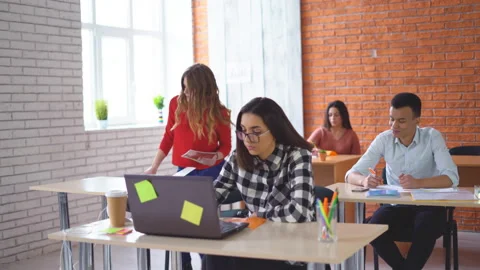 A group of young students sitting in the classroom and listening attentively to Stock Footage 86751496
