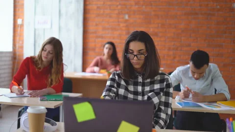 A group of young students sitting in the classroom and listening attentively to Stock Footage 86753306