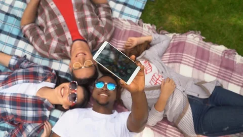 Group of young students take a selfie while lying on the grass Stock Footage 126282403