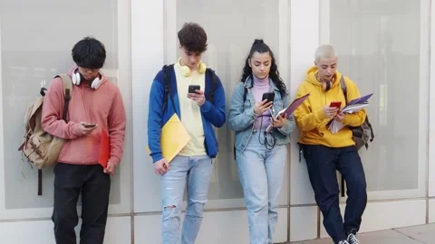 Group of young students on a wall looking at the smartphone. Social networks Stock Footage 171675451