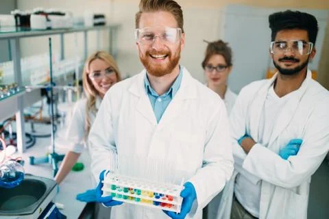 Group of young successful scientists posing for camera Фото
