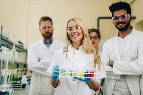 Group of young successful scientists posing for camera Stock Photos