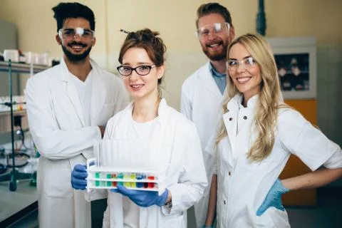 Group of young successful scientists posing for camera Stock Photos