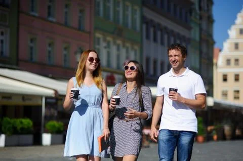 Group of young tourists stroll through the streets of an ancient city. Stock Photos