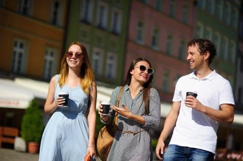 Group of young tourists stroll through the streets of an ancient city. Stock Photos