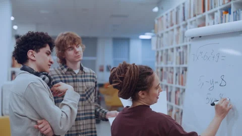 Group of Young University Students Collaborating on a Difficult Math Equation in Stock Footage 335127315