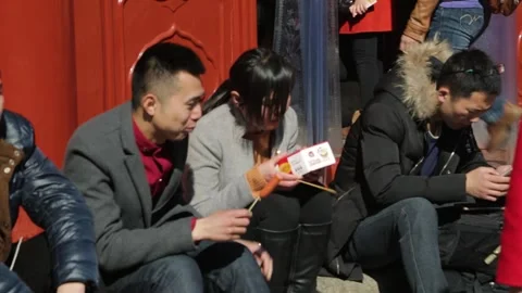 Group of Young Visitors Eating Snacks and Using Phones at Forbidden City Stock Footage 345820603