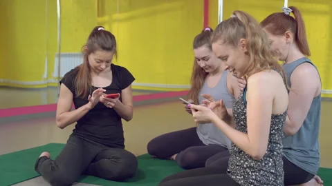 Group of young women actively using phones in fitness studio Stock Footage 132201704