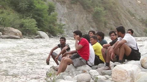 A group of youngster chatting by riverside Stockbeeldmateriaal 45309384
