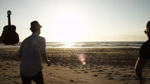 Group of youngsters running on beach to sundown Stock Footage 67719257