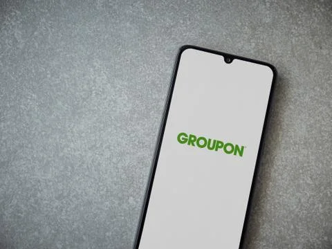 Groupon app launch screen with logo on the display of a black mobile smartpho Stock Photos