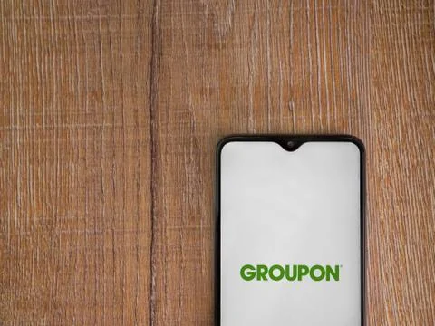 Groupon app launch screen with logo on the display of a black mobile smartpho Stock Photos
