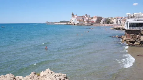 Groups of bathers walk in the shallow water near the beach of Sitges, Spain. Stock Footage 167705799