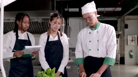 Groups of diversity students watching a head chef teacher showing chopping .. Stock Footage 245082902
