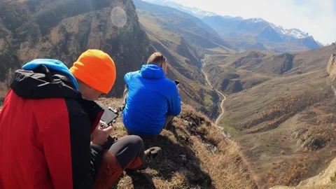 Groups of people are sitting on the edge of a cliff Stock Footage 171956683