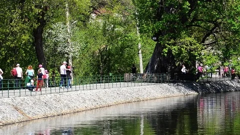 Groups of people walking on a levee that borders a recreational lake in the w Stock Footage 72266382