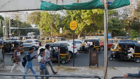 Groups of people walking on sidewalk next to busy rush hour road in Mumbai Stock Footage 145049520