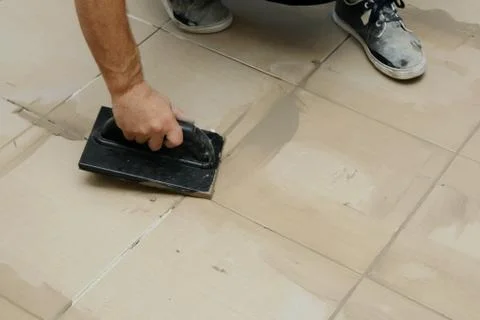 Grouting ceramic tiles, close up. Putting fugue on tiles on the floor Stock Photos