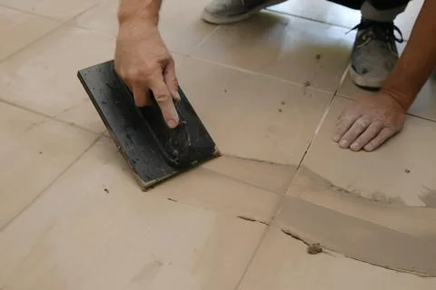 Grouting ceramic tiles, close up. Putting fugue on tiles on the floor Stock Photos