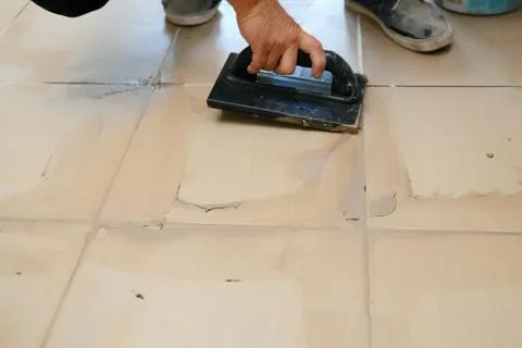 Grouting ceramic tiles, close up. Putting fugue on tiles on the floor Photos