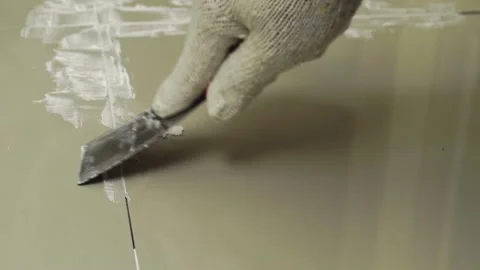 Grouting ceramic tiles. Tilers filling the space between tiles using a Stainless Stock Footage 171763407