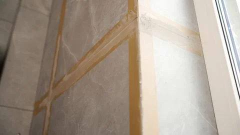 Grouting process on grey marble look porcelain tiles on a wall corner durin.. Stock Photos