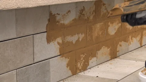 Grouting tiles with brown grout Stock Footage 111865922