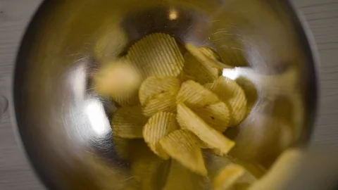 Groved potato chips falls in slow motion to the iron bowl, groved fried potatoes Stock Footage 104823484