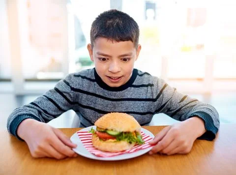 Growing boys have the biggest appetite. a young boy looking at his delicious Stock Photos