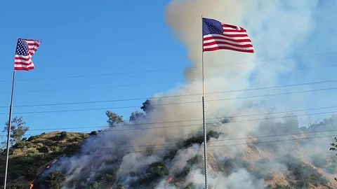 Growing Brush Fire Smoke Covers The Hill With American Flag Stock Footage 247488664