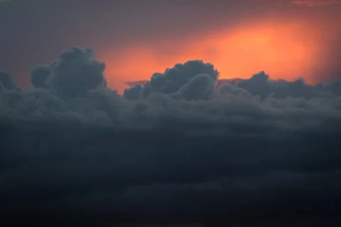 Growing cumulus clouds with the diffuse light of the setting sun as background Stock Photos