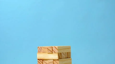 Growing tower stack of board game Jenga on a blue background Stock Footage 220614266