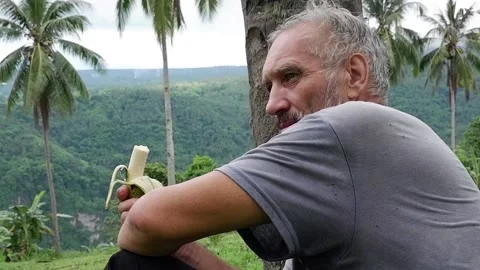 A grown man eats a banana. Video stock 137554530