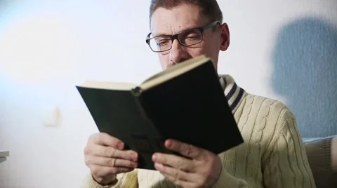 A grown man reading a book Stock Footage 60744033