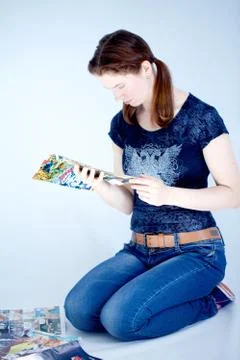A grown up woman reads some comics Stock Photos