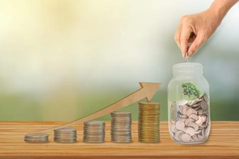 Growth chart of coins stack and Hand put coin in glass bottle. Concept invest Stock Photos