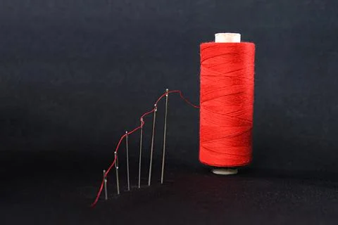 Growth graph in the form of a red thread passed through needles growing to the c Foto stock