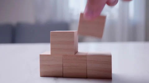 Growth reduction process concept - Detail of hand removing blocks from Stock Footage 259855323
