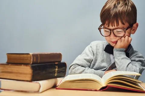 Growth is the result of knowledge. Studio shot of a smart little boy reading 写真素材