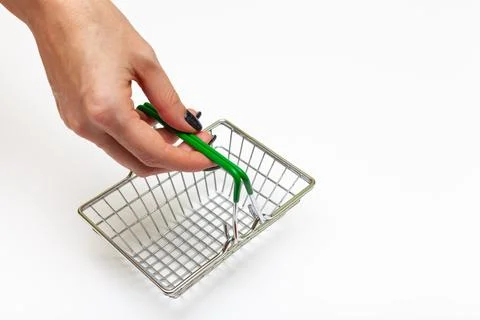 Grubby hand holds an empty miniature grocery basket Stock Photos