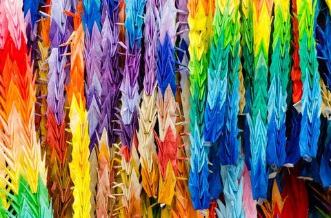 Grullas de papel colorido u origami colgadas de un arbol como decoracion en e Stock Photos