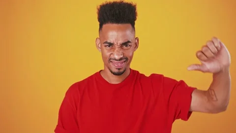 Grumpy african american guy showing thumb down gesture Stock Footage 137980898