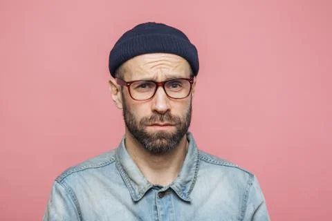 Grumpy bearded man with offended expression, being dissatisfied with somethin Stock Photos