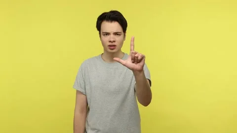 Grumpy disrespectful young guy showing looser gesture pointing on you, bullying Stock Footage 148357203